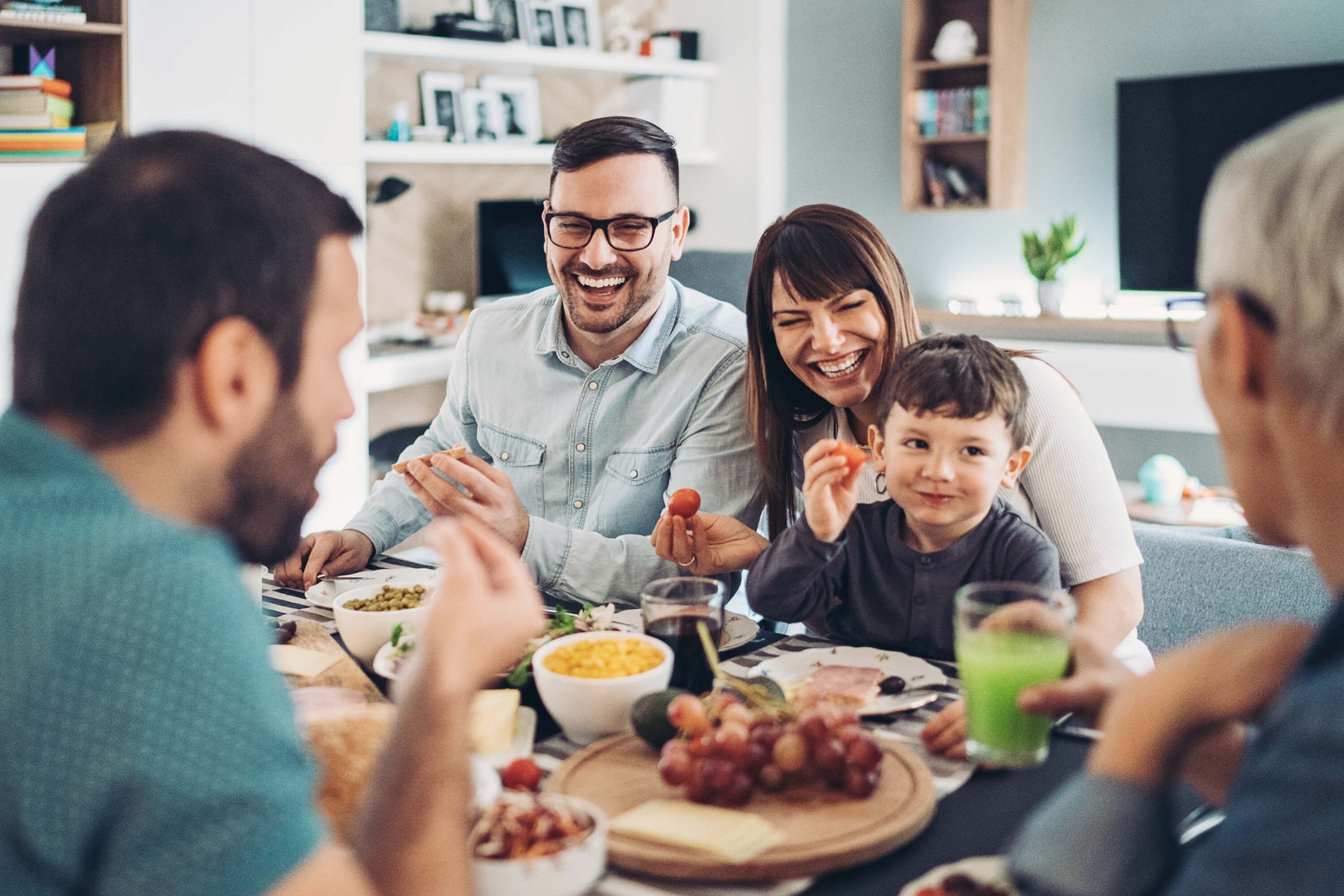 Family laughing and eating at the dinner table